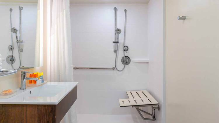 ADA bathroom shower with grab bars and seat