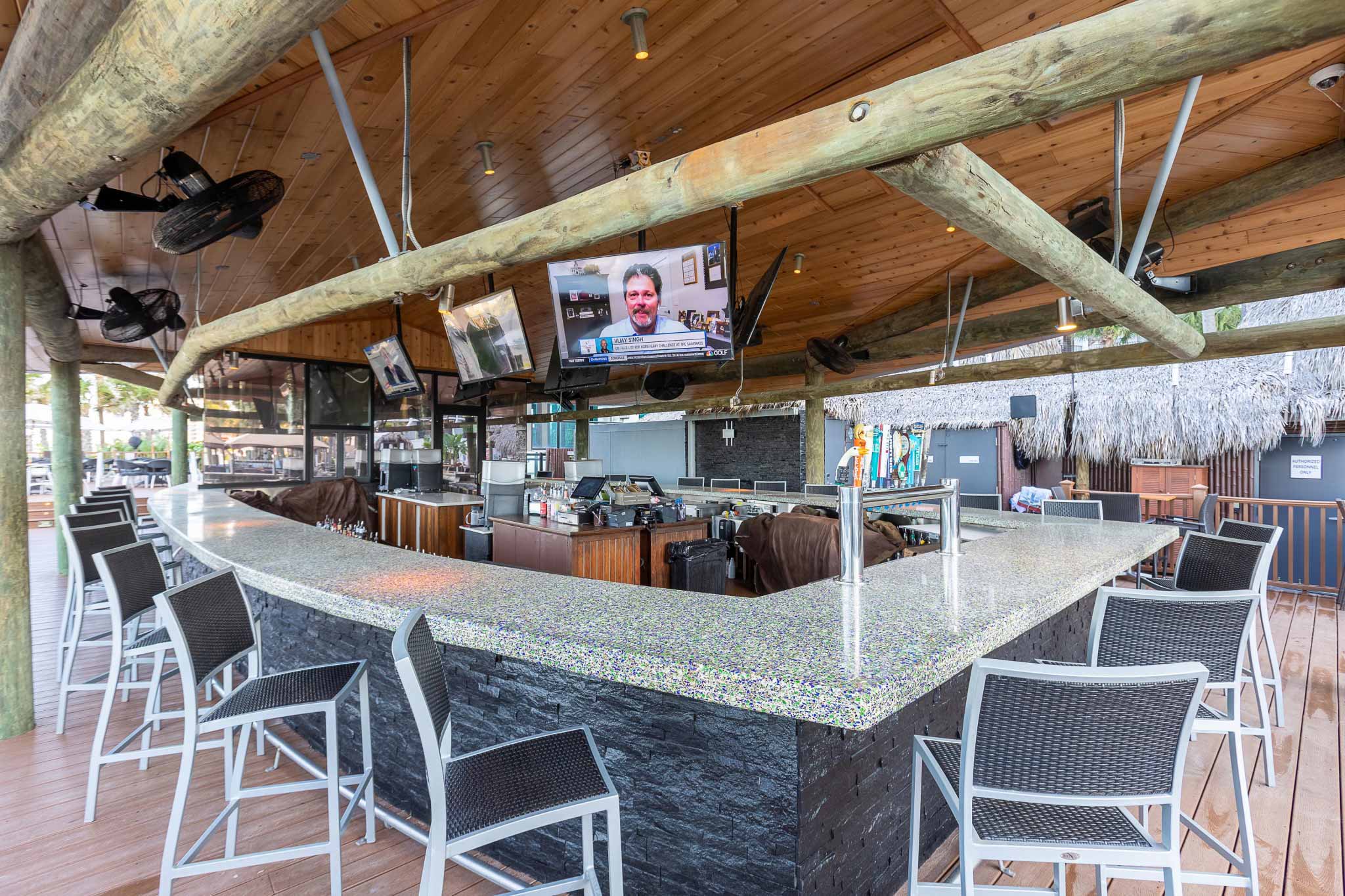 Outdoor bar with TVs and bar stools