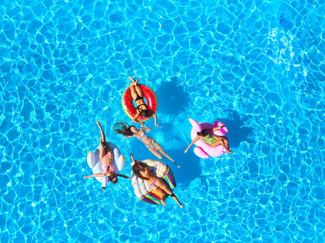 People floating in the pool on inflatable toys