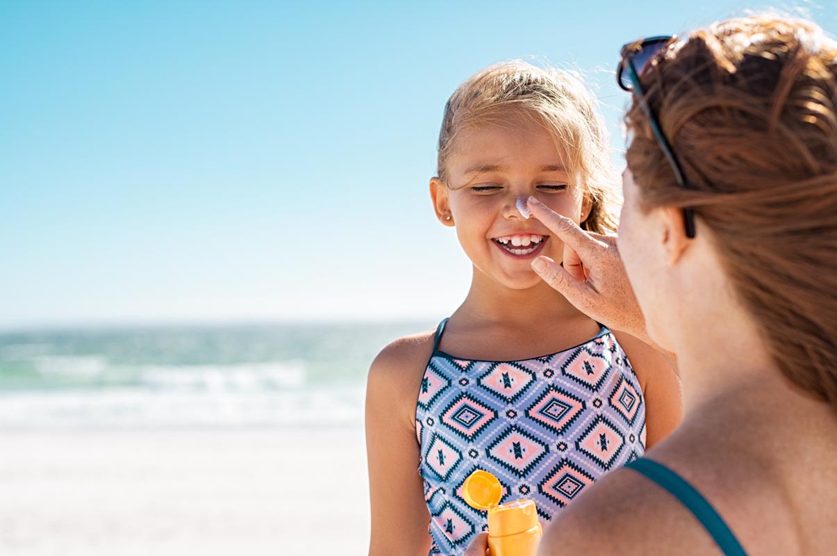 Mother Applying Sunscreen to a Child on the Beach